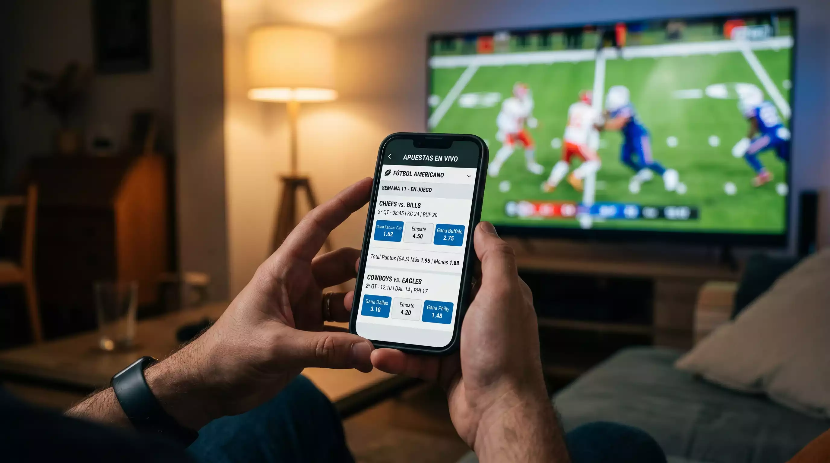 Persona apostando en vivo desde un telefono movil mientras ve el Super Bowl en television